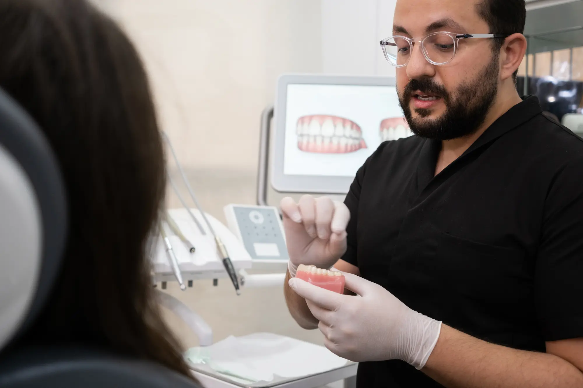 bearded-dentist-with-glasses-explaining-teeth-trea-2024-11-25-12-35-22-utc