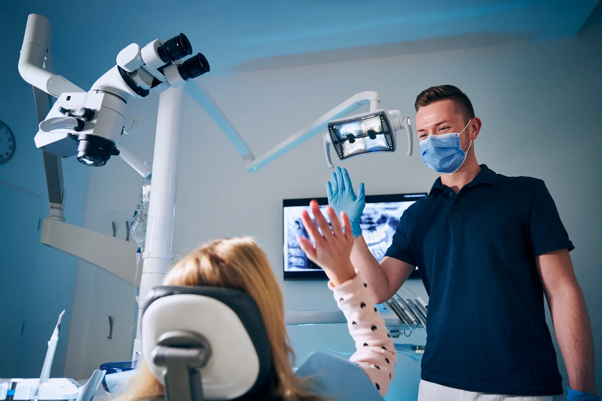 dentist-giving-high-five-to-girl-in-modern-dental-2025-02-16-09-29-22-utc