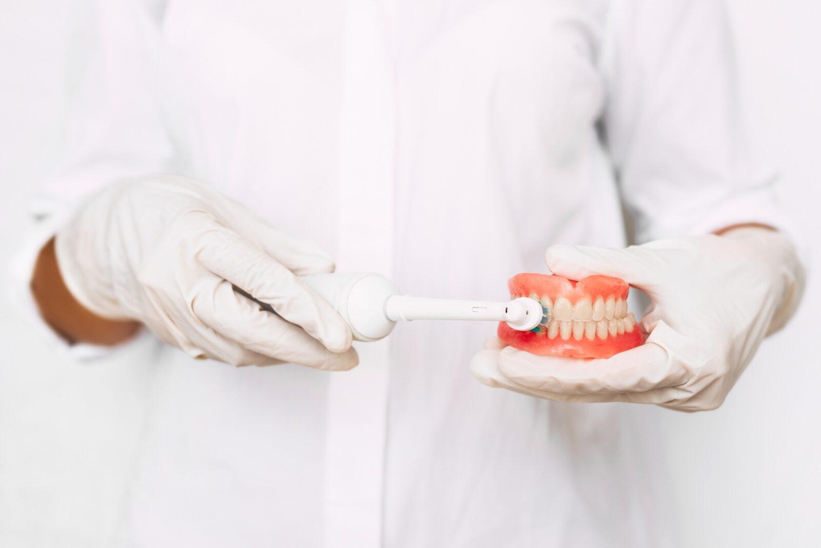 oral-hygiene-close-up-hand-dentists-are-demonstrating-how-to-brush-their-teeth-correctly
